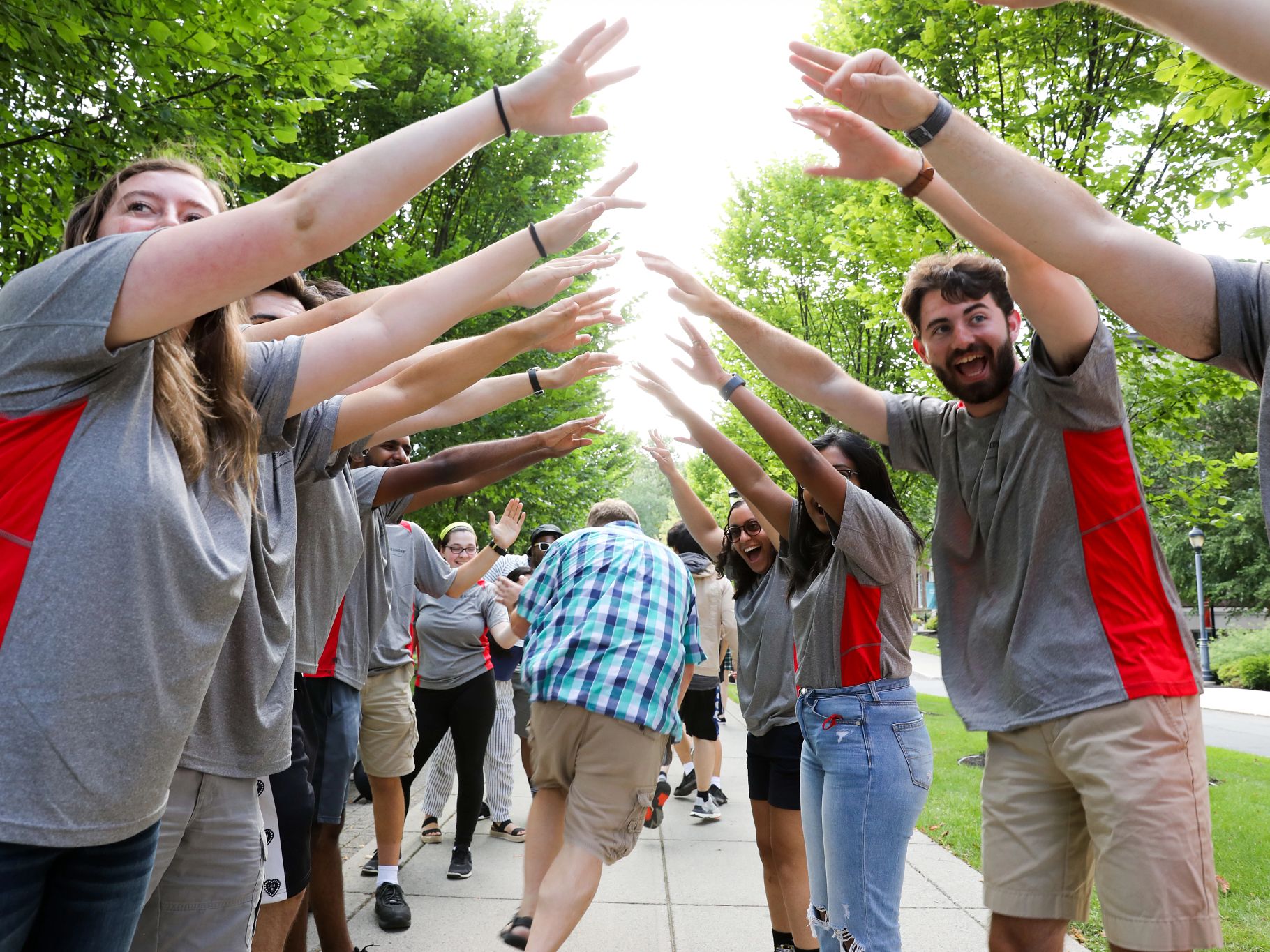 Students form an arch with their hands for new students to run through