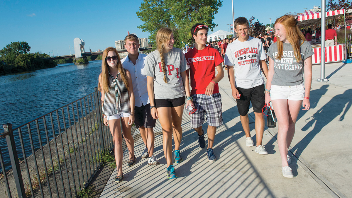 Six kids walk along the Hudson River in troy wearing RPI shirts