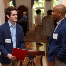 Two men in blazers are talking