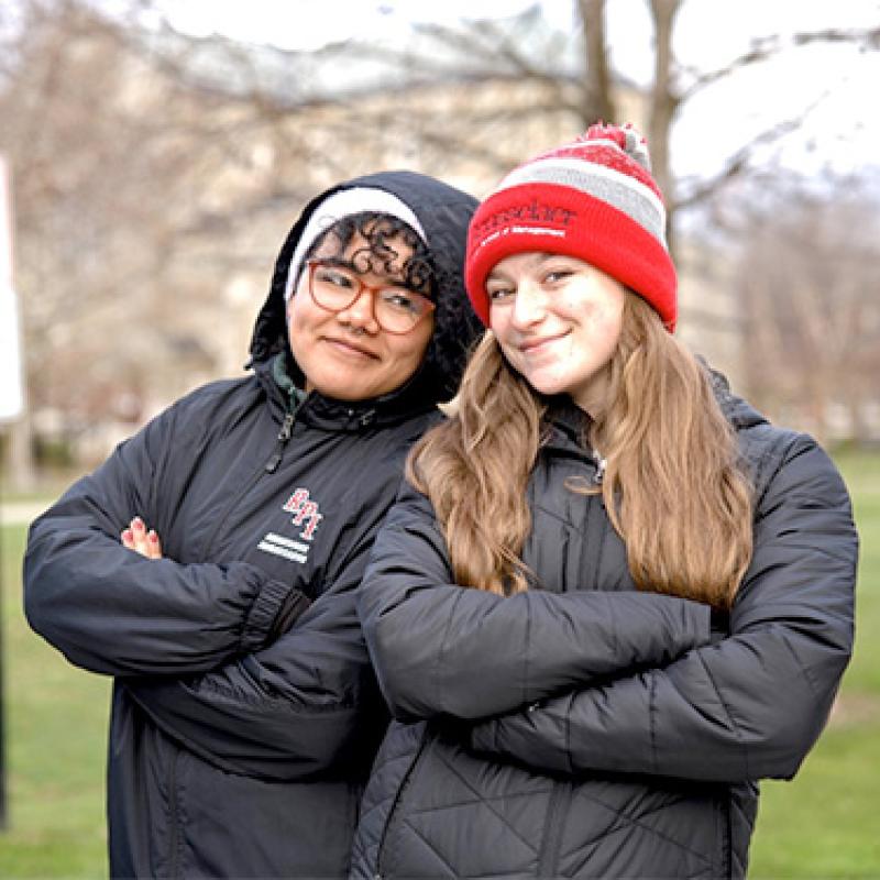 Two RPI students pose with their arms folded and smile for the camera