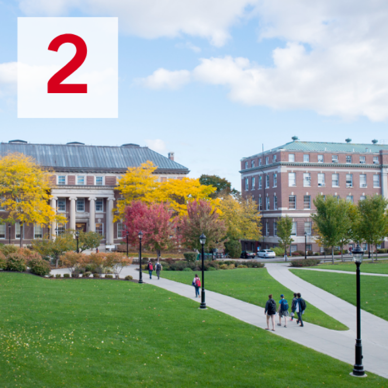Beautiful picture of a few students walking to the Troy Building on a sunny day in the Fall